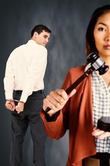 Composite image of businesswoman banging a law hammer