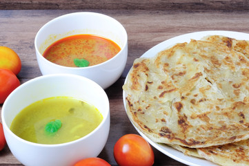 Roti canai or roti Prata with curry sauce and Dhal curry sauce, famous Malaysian food.