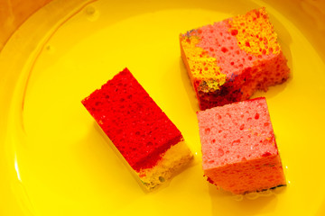 three sponges with yellow paint