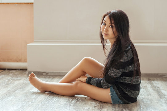 asian female sitting on wood floor
