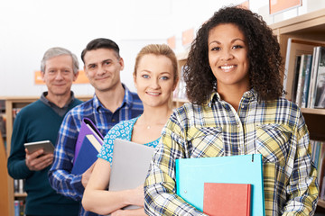 Group Of Mature Students Studying In Library