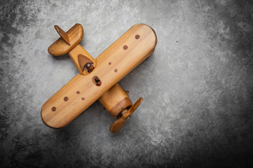 Toy wooden airplane on textured background