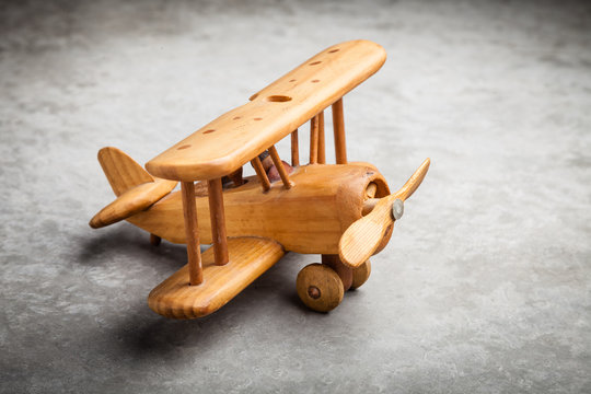Toy wooden airplane on textured background