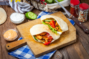 Fried chicken meat with vegetables in pita bread