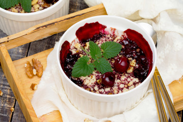 Homemade cherry crumble on a wooden background, selective focus.