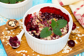 Homemade cherry crumble on a wooden background, selective focus.
