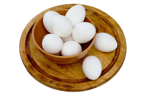 Homemade chicken eggs in a bowl on a wooden board