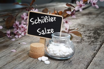 Schuessler Salze auf altem Tisch mit Kirschblüten