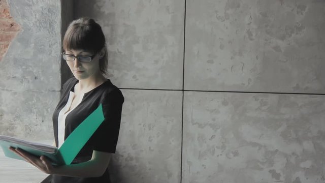 Business girl with green folder in hand writes HD