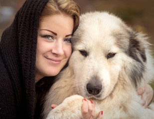 Woman cuddling a big shepherd dog
