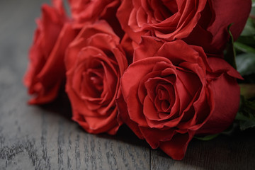 five red roses on wooden table, shallow focus