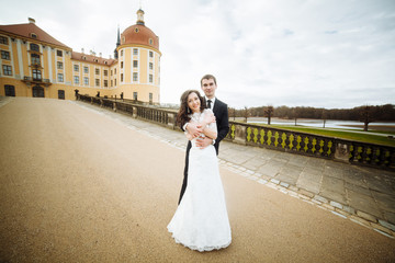 Obraz premium two couple after wedding in tne park near the castle