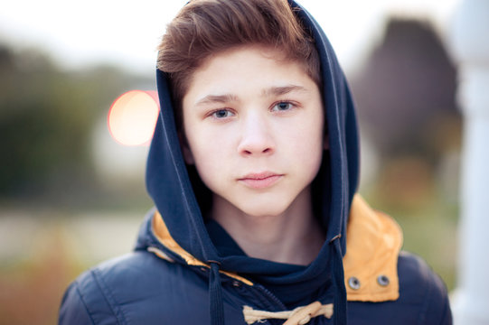 Blond teenager boy 14 15 year old wearing hoodie outdoors. Looking