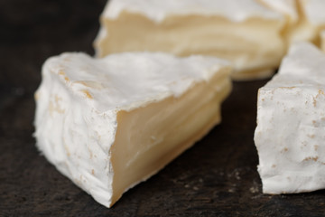 Piece of brie cheese on wooden surface