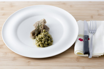 beef stew with peas served on a white plate