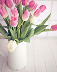 Pink and white tulips in a vintage white tin jar