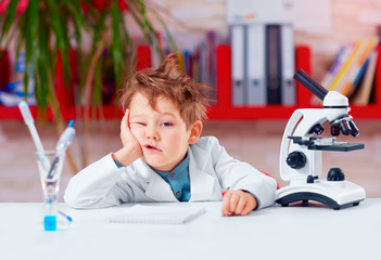 young boy, kid is bored at practical lesson in the school lab © Olesia Bilkei