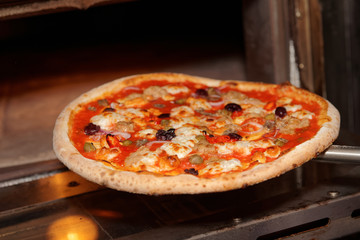 Taking a pizza out of oven