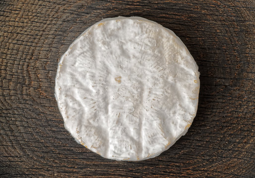 Piece of brie cheese on wooden surface