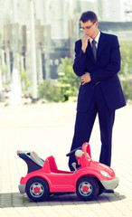 Businessman Contemplating a Red Toy Car the Thing Next Business