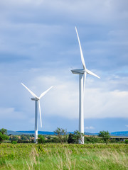 Fototapeta premium Windmills standing in fiels during summer