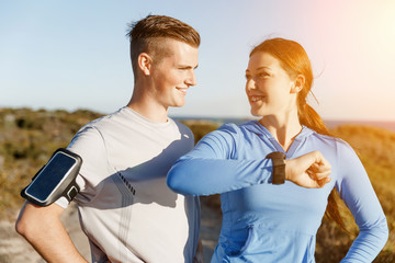 Runner woman with heart rate monitor running on beach