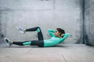 Young woman performing core crunch exercise 