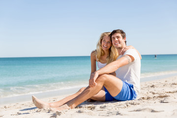Fototapeta na wymiar Romantic young couple sitting on the beach