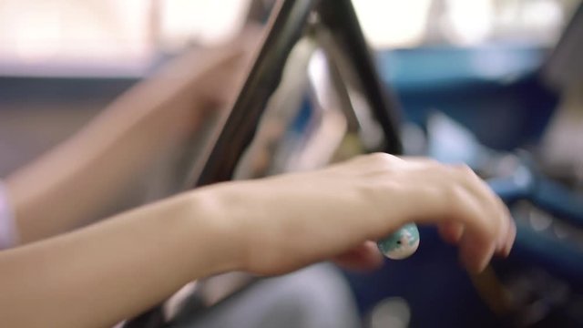 Preteen Boy Learning To Drive A Car. The Kid Is Sitting In A Vintage Auto From The 1950s, Playing With The Steering Wheel And The Gear