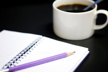 Purple pencil and notebook open on the table.