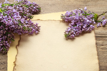 Lilacs and freesias on vintage paper background