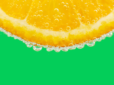 Close-up orange in sparkling water green background