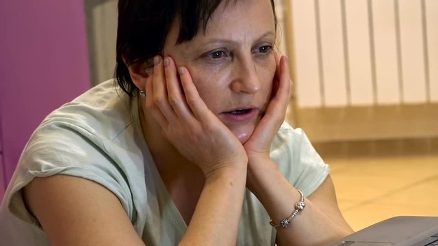 Mature Woman at Home in Front of Laptop Teaches English Online