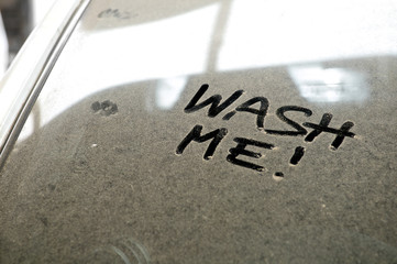 Car dust word on dirty rear window of the car and inscription WASH ME!. Front and side view. Close up of text with handwriting.