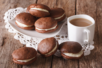 American Whoopie pie pastry and coffee with milk close-up. horizontal
