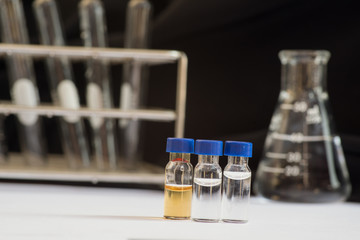 Blue cap vial in front of Laboratory glassware