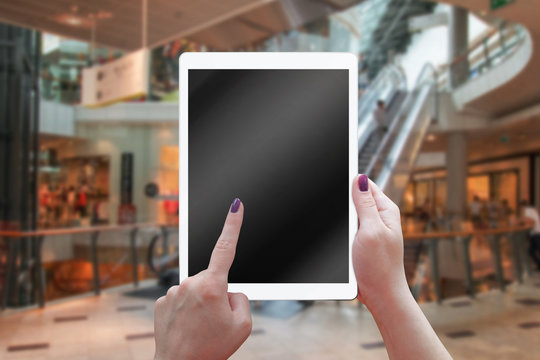Tablet with blank screen in woman hands. Shopping time in mall.