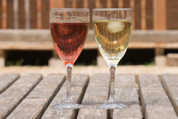 Red and white wine with ice inside against a beautiful background.
