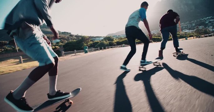 Multi-Ethnic Group of Skaters Skateboarding Down Street at Seasi