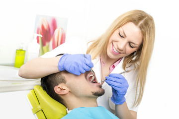 Obraz na płótnie Canvas Dentist is working on the patient at the dentist office. Dental care and health care concept