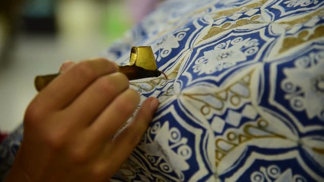 Detail of waxing the drawing to textile for making batik