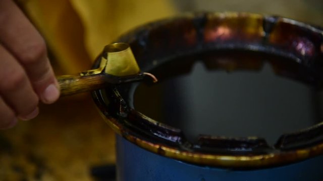 Filling canting with wax for making batik
