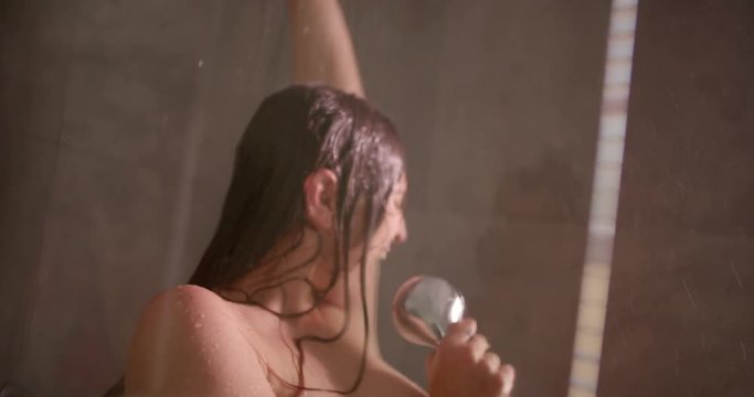 Image of funny young brunette singing in shower