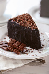 Chocolate cake with chocolate cream on plate, on light background