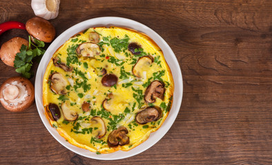 omelet with mushrooms in a plate on wooden table