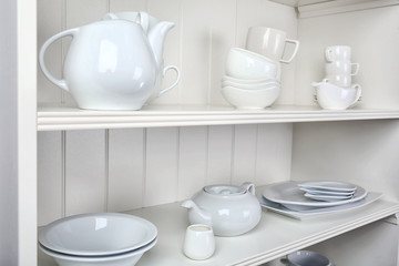 Fototapeta na wymiar Dishes in cupboard in the kitchen