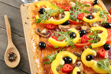 Rectangle delicious pizza and vegetables on the table, close-up