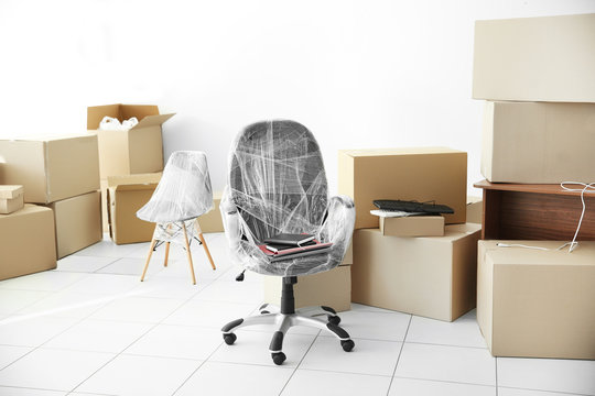 Moving cardboard boxes and personal belongings in empty office space