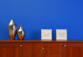 Wooden chest of drawers on blue wall background