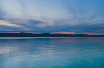 Evening view of the lake and mountains at sunset, blue hour. Balaton, Hungary.